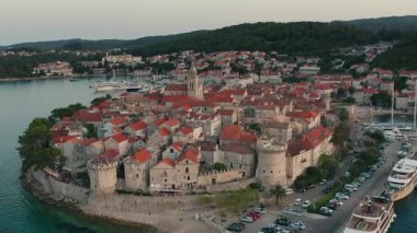 The historic fortress of Korcula, a medieval landmark with impressive stone towers and defensive walls on the Adriatic coast of Croatia, captured in a scenic aerial drone shot.