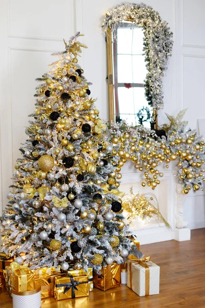 beautiful christmas tree with golden decorations near the fireplace