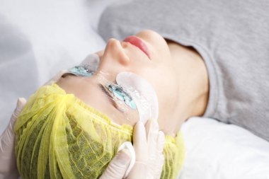 Kirpik uzatma prosedürü. Uzun kirpikli kadın gözleri. Spa salonunda kozmetik prosedür.