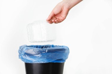 Beyaz arka plandaki bir kadın tarafından plastik konteynırın çevre dostu bir şekilde imha edilmesi.