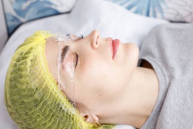 Kadın kaş kaplaması yapıyor. Kompozisyonu yakın plan.