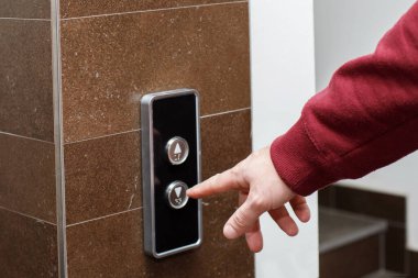 Yakın plan adam asansörü çağırmak için düğmeye basıyor.