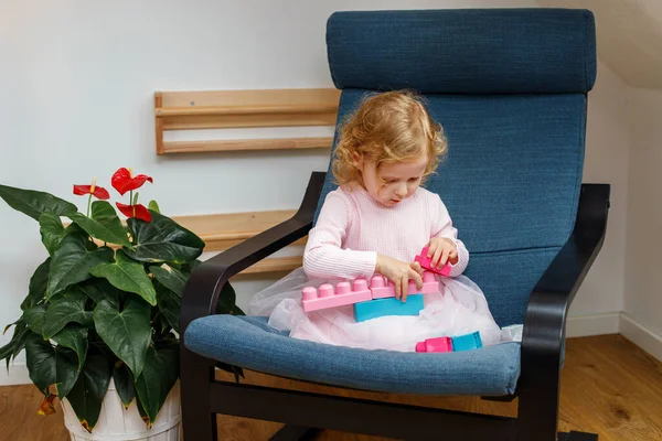 Девушка Играет Строительным Блоком Сидя Кресле Дома — стоковое фото