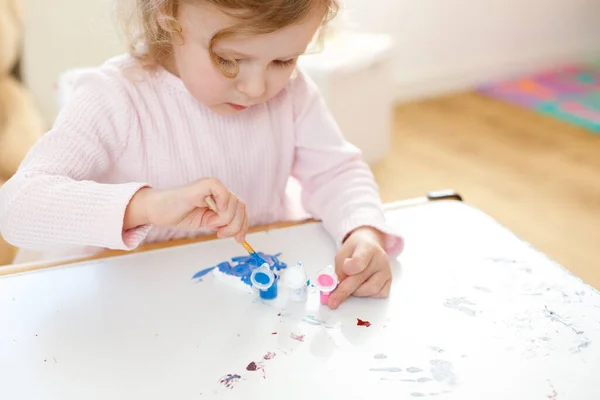 Masasında Renkli Fırçalar Ressamlarla Küçük Bir Kızın Yakın Çekim Portresi — Stok fotoğraf