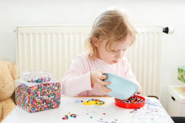 Mała Dziewczynka Bawiąca Się Kolorowymi Koralikami Jej Domu Biurko Zabawne — Zdjęcie stockowe