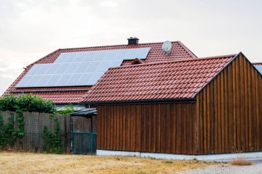 Güneş panelleri olan ahşap bir ev. Alternatif enerji, tasarruf kaynakları ve sürdürülebilir yaşam tarzı kavramı.