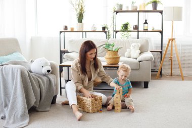 Anne ve çocuk oturma odasında yerde oynuyorlar. ebeveynlik