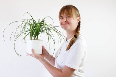 Tencerede yeşil bitkisi olan bir kadın. ev için bitkiler