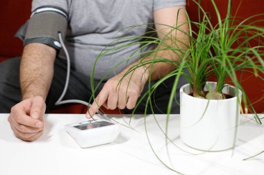 Kan basıncı makinesi, diyabet riski olan şişman bir adam taşınabilir kan basıncı makinesi, diyabet konsepti kullanıyor.