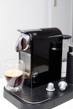 Kapsül kahve makinesi ve bir fincan espresso.