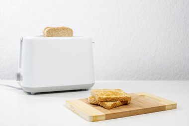 Masanın üzerinde ekmek kızartma makinesi var. Kahvaltı, öğle yemeği.