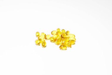 Beyaz arka planda sarı jelatinli, vitaminli, besin takviyeli kapsüller