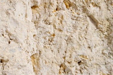 Bir kayanın arka planına yakın çekim. Erozyon izleri olan kaya duvarı..