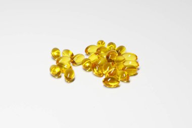 beyaz zemin üzerinde turuncu D vitamini kapsülleri