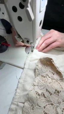 Kadın bir terzi etek dikiyor. Bir moda uzmanı, bir moda fabrikası veya stüdyo, bir atölye, bir tasarım girişimi vizyonu.