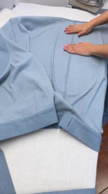Dişi bir terzi kadın ütü diker kot elbise diker. Moda uzmanı, moda fabrikası veya stüdyo, atölye, bir tasarım girişimi vizyonu.