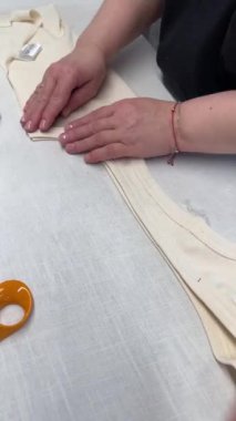 Dikiş işlemi. Bir terzi, fabrikada ya da moda stüdyosunda dikilmiş bir ürünü ütüler..