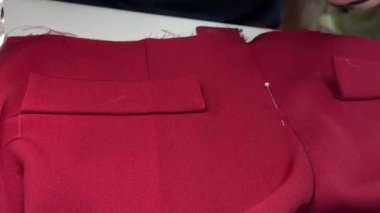 Pantolon dikme süreci. Yetenekli bir zanaatkar, canlı bir zanaat ortamında hassas teknikler ve aletler kullanarak dikiş dikmeye odaklanır. Dikiş atölyesi özel giyim hazırlıyor..