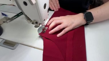Pantolon dikme süreci. Yetenekli bir zanaatkar, canlı bir zanaat ortamında hassas teknikler ve aletler kullanarak dikiş dikmeye odaklanır. Dikiş atölyesi özel giyim hazırlıyor..