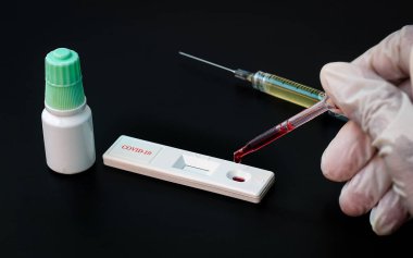 Doktor COVID-19 virüsü için test kitine kan bırakıyor. Yeni virüs için test kartı ayarlanıyor. Coronavirus covid-19 için hızlı test ayarlanıyor..