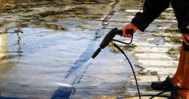 İşçiler çatı temizlemek için su püskürtücü kullanırlar 