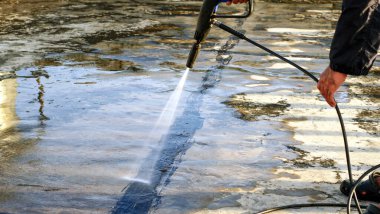 İşçiler çatı temizlemek için su püskürtücü kullanırlar 