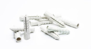 Beyaz arka planda plastik kaplamalar, duvar tıpası - vida çapası olarak da bilinir, inşaat araçları.