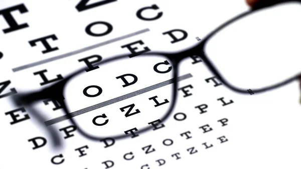 白い背景の目のテストチャートの黒い眼鏡 — ストック写真