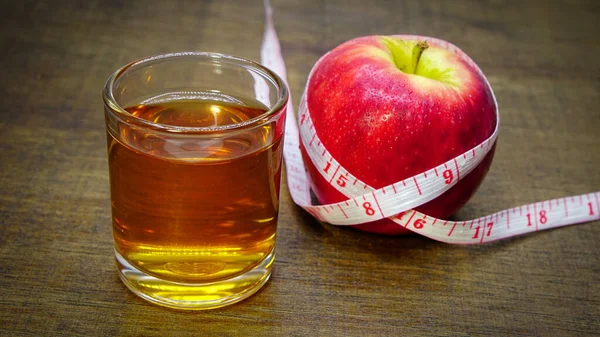 Apple cider vinegar, apple and apple juice with tape measure. healthy food, drink for weight control in summer. Health care ideas for weight loss.