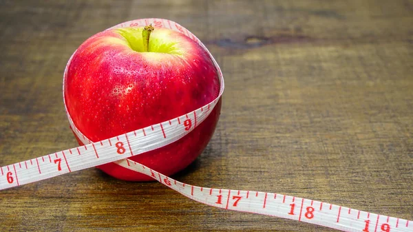スリムな図 健康的な食品のアイデアを失う テキストのためのコピースペースと木製の背景に閉じテープや新鮮な果物のリンゴを測定 — ストック写真