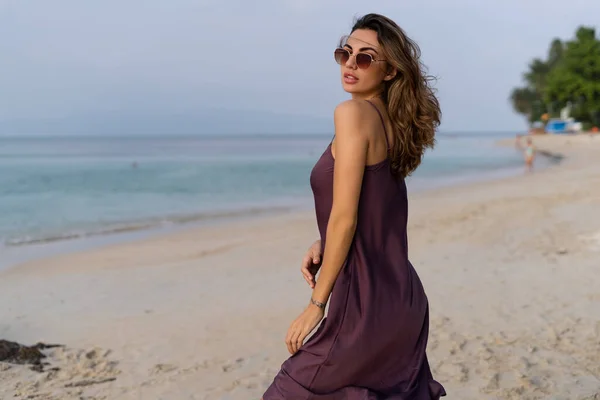 Günbatımında Plajda Ipek Elbiseli Güneş Gözlüklü Zarif Duygusal Kadın — Stok fotoğraf