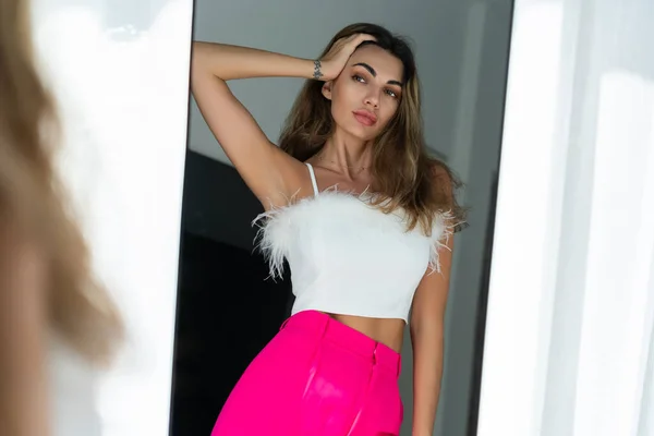 时尚粉红裤子 头戴镜子 穿着时尚粉红裤子 在家里卧室里摆出一副时髦的造型 为派对做准备 穿衣打扮 — 图库照片