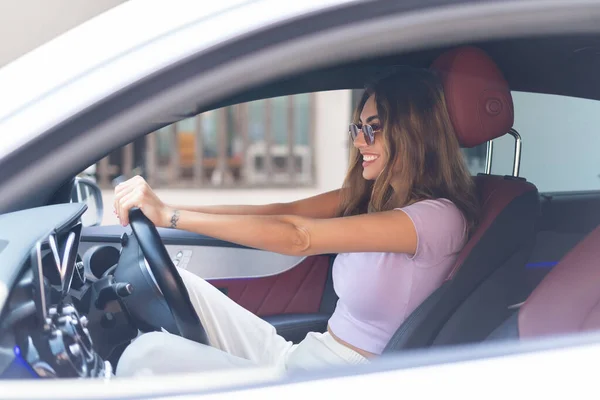 stock image Beautiful young happy smiling woman driving her expensive luxury car, traveling.