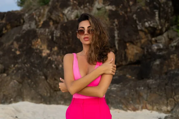 时尚时尚 苗条身材 穿着时髦的粉色裤子 身穿紧身衣 戴着太阳镜 傍晚时分在热带海滩上亮相的年轻女子 — 图库照片
