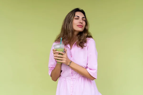 在炎炎夏日 穿着休闲装 身披绿衣 身披绿衣的年轻女子正享受着鲜冰绿茶加牛奶 — 图库照片