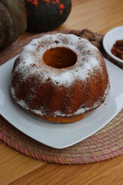 Tahta bir tabakta kuru üzümlü ve cevizli ev yapımı balkabaklı kek.