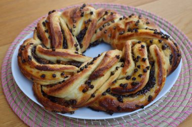 Çikolata ve portakal reçeli Brioche ekmeğini ahşap bir masada örer. 