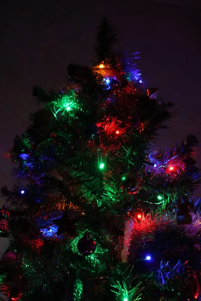 Weihnachtsbaum Mit Glaskugeln Und Buntem Lichterkranz Auf Dunklem Hintergrund — Stockfoto