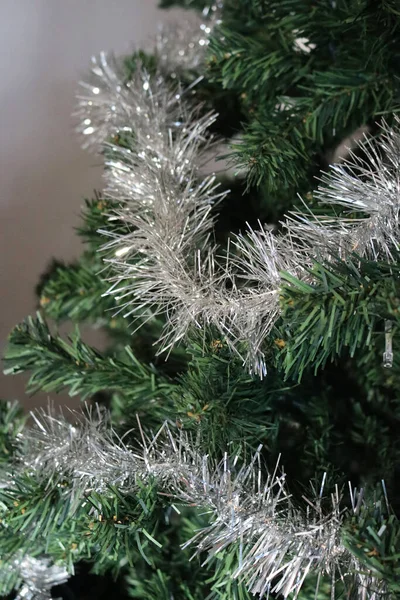 緑のプラスチッククリスマスパインツリー上の銀のガーランド装飾のクローズアップ — ストック写真