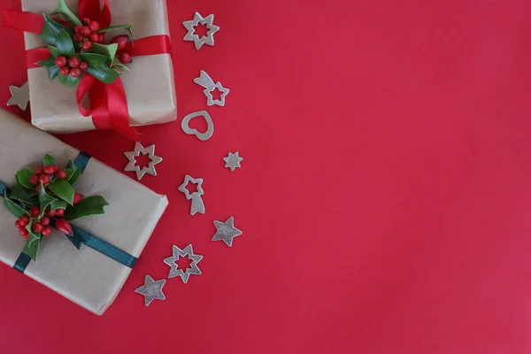 两个圣诞礼物 荷莉枝 红色浆果 红色背景 有复制空间的银质装饰 — 图库照片