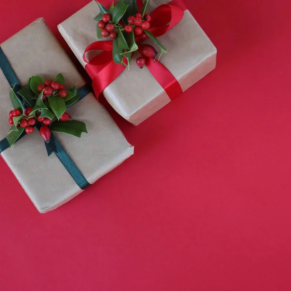 Δύο Χριστουγεννιάτικα Δώρα Κλαδί Holly Κόκκινα Μούρα Και Ασημένια Διακοσμητικά — Φωτογραφία Αρχείου