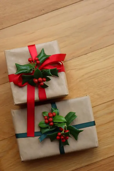 Два Різдвяні Подарунки Прикрасою Холлі Червоними Ягодами Дерев Яному Фоні — стокове фото