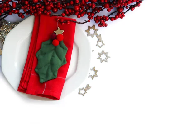 전통적 크리스마스 식탁에 세라믹 접시가 배경에 홀리의 과빨간 식탁보 — 스톡 사진