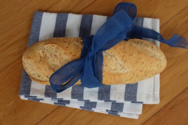Whole Grain bread with flax seeds with blue tied bow on a wooden table 