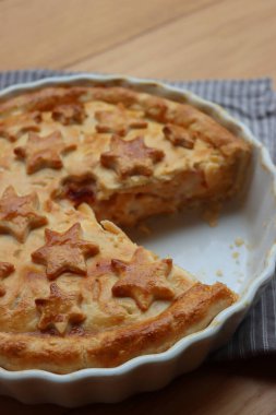 Cut Italian Timballo or Timbale filled with pasta and bechamel with tomato sauce on wooden table