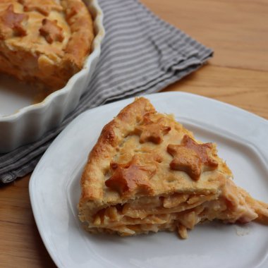 Cut Italian Timballo or Timbale filled with pasta and bechamel with tomato sauce on wooden table