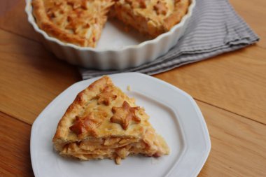 Cut Italian Timballo or Timbale filled with pasta and bechamel with tomato sauce on wooden table