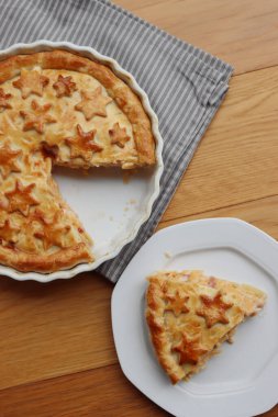 Cut Italian Timballo or Timbale filled with pasta and bechamel with tomato sauce on wooden table