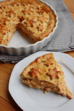 Cut Italian Timballo or Timbale filled with pasta and bechamel with tomato sauce on wooden table