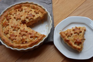 Cut Italian Timballo or Timbale filled with pasta and bechamel with tomato sauce on wooden table